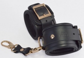 Черные кожаные наручники с золотистыми пряжками и карабином